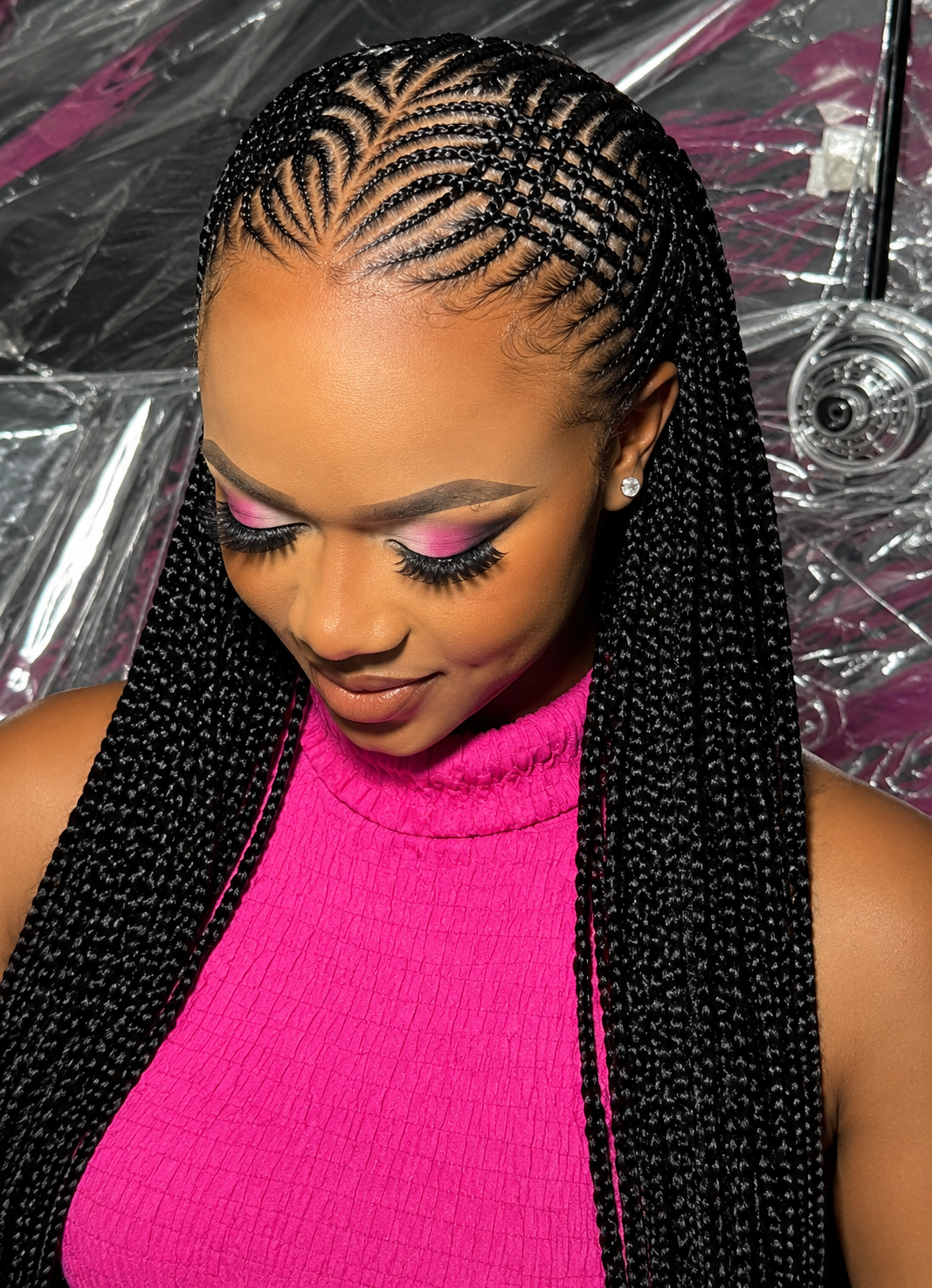Client wearing intricate tribal feed-in cornrow braids with long braided lengths at Violette Braiding Hair in Austin, Texas